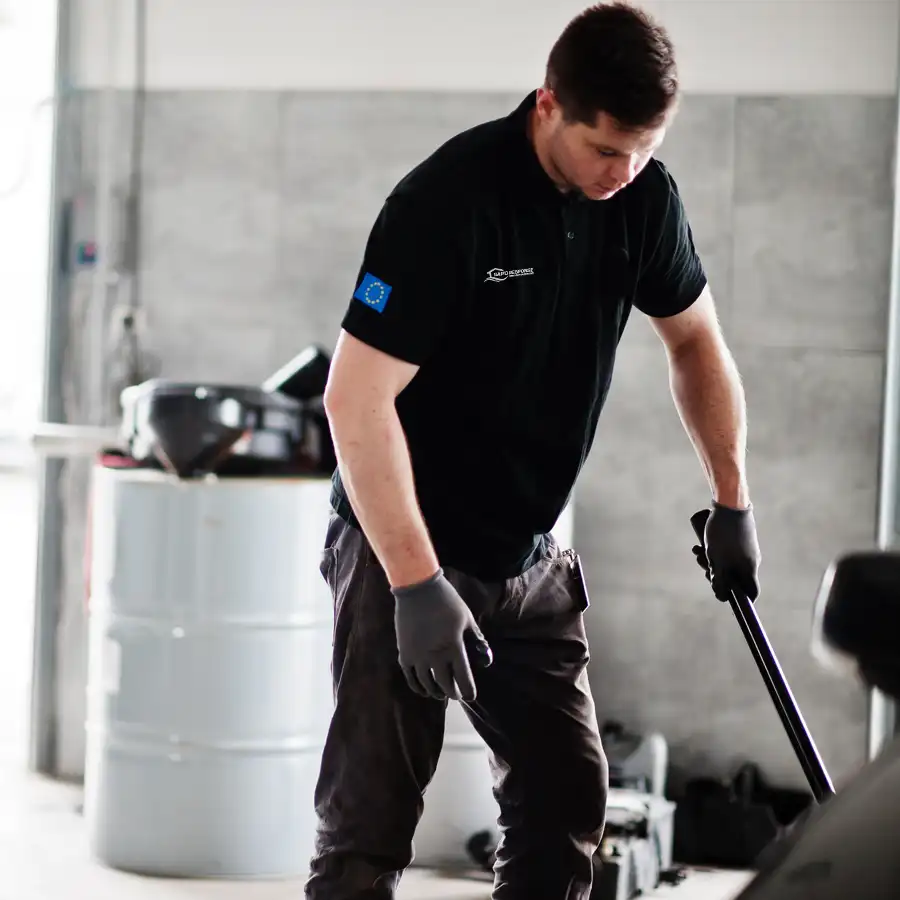 Technician cleaning water in a commercial garage